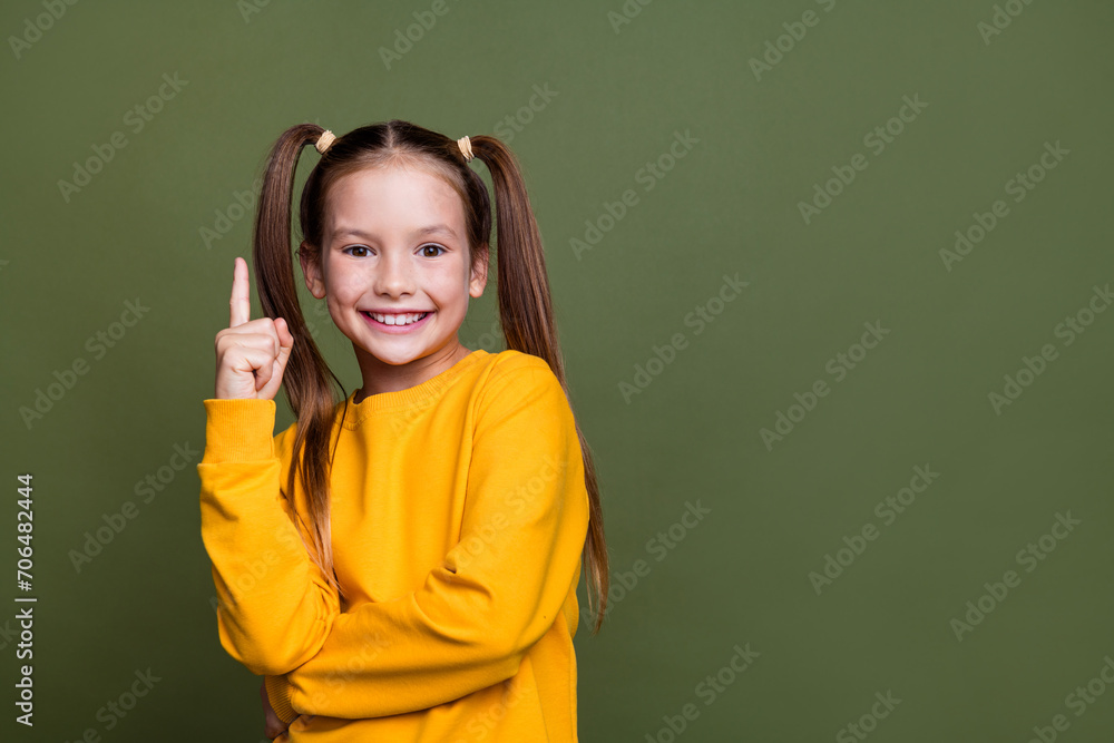 Canvas Prints Portrait of smart clever small kid with tails dressed yellow sweatshirt raising finer up has idea isolated on khaki color background