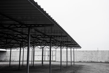 Parking for cars from iron profiles and roofs, on a city street on a cloudy day. Image for your design or creative illustrations.