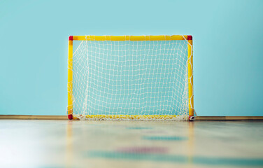 Children sport goal with empty net placed in gym for playing futsal or mini football indoor.
