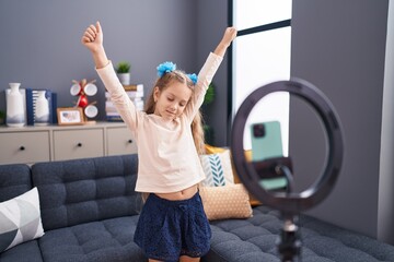 Adorable caucasian girl recording video dancing at home