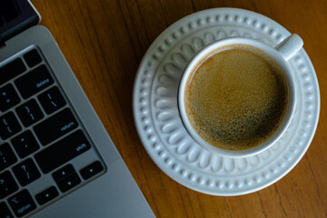 foto minimalista superior horizontal de computador aberto e xícara de café sobre a mesa.