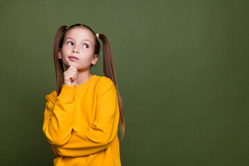 Photo of thoughtful schoolgirl with ponytails wear yellow pullover look at proposition empty space...