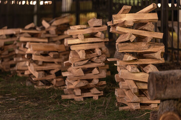 Neatly stacked firewood in the backyard in the evening.