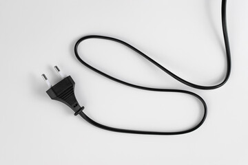 black plastic plug from an electrical appliance with a wire, isolated on a white background
