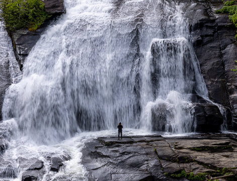 Man stands before dramatic High Falls in Dupont Forest State Park near Brevard, NC