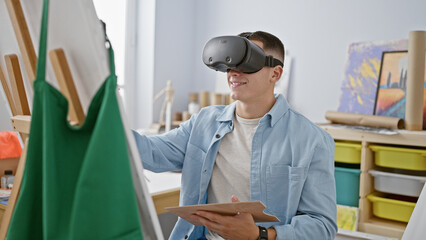 A young man engages with virtual reality in a creative indoor studio while holding a tablet.