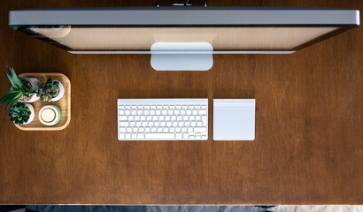 Top view, computer on a wooden table, work desk.