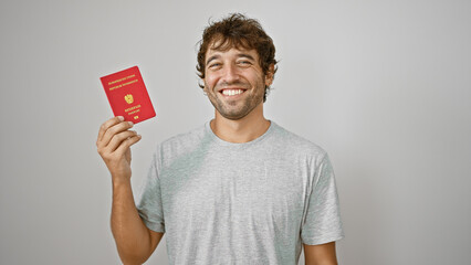 Joyful young man, a beaming patriot, confidently holds his austrian passport against an isolated white wall, ready for european adventure!