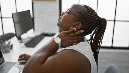 Tired african american business woman feeling the burn - suffering cervical pain while crunching...