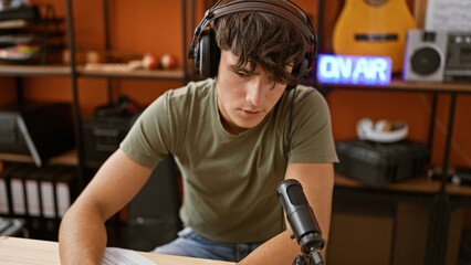 Handsome young hispanic teenager live at radio studio, seriously presenting news while lounging...