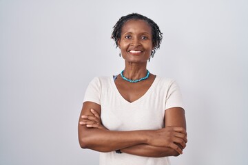 African woman with dreadlocks standing over white background happy face smiling with crossed arms...