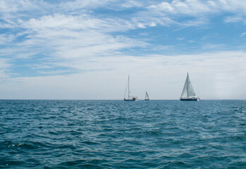Fototapeta premium Three boats sailing on Lake Michigan on a perfect summer day.