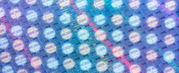 background of silicon wafer with microchips reflecting different colors used in electronics for the...