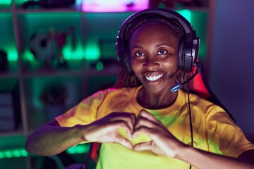 African american woman streamer smiling confident doing heart symbol with hands at gaming room