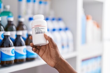 African american woman customer holding pills bottle at pharmacy