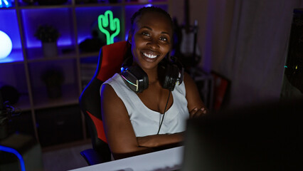 Smiling woman with headphones in a gaming room illuminated by neon lights at night, depicting...