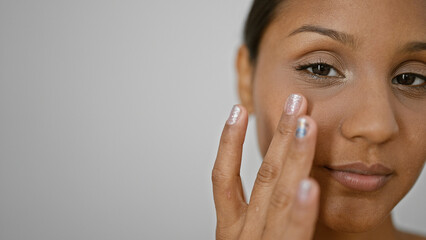 Young latin woman touching baggy eyes with fingers over isolated white background
