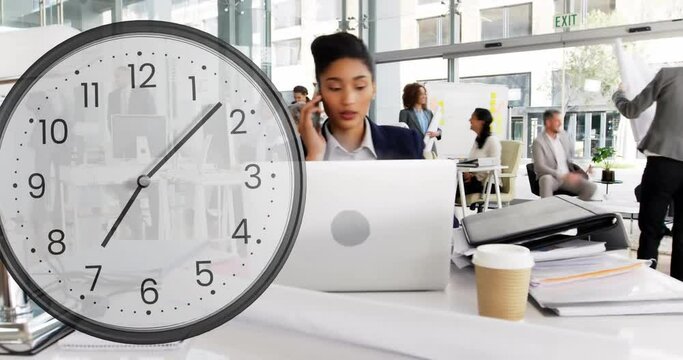 Animation of clock ticking over biracial businesswoman in office