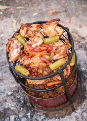 Zurbian dinner. The barrel has been uncovered and it is ready and well cooked. It contains chicken, vegetables and rice. It is placed on a wire rack and it has been transferred to the serving tray. - obrazy, fototapety, plakaty