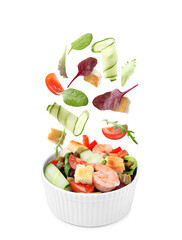 Ingredients falling into bowl with tasty salad on white background