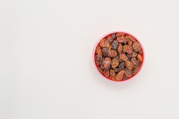 Raisins in a bowl on a white background, with copy space. Macro image. Healthy snack.