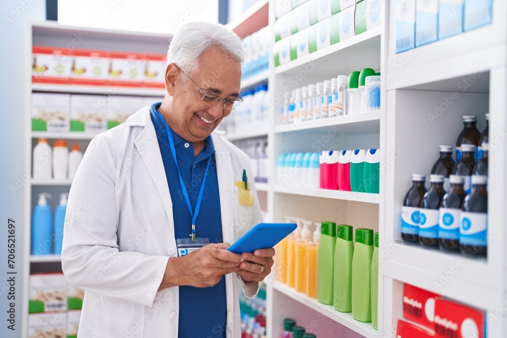 Canvas Prints Middle age grey-haired man pharmacist using touchpad working at pharmacy