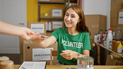 Young woman volunteer receiving dollars smiling at charity center