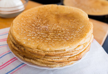 Process of baking pancakes in pans on kitchen stove. stack of hot pancakes