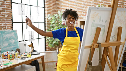 African american woman artist listening to music drawing at art studio