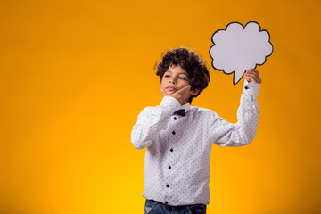 Thoughtful child boy holding speech bubble. Education and curiosity concept
