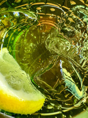 sparkling water served with ice and lemon in a green crystal glass