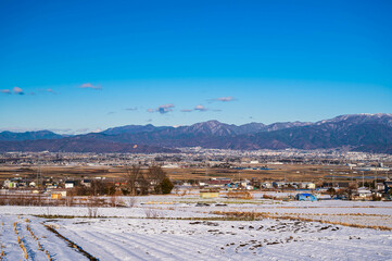 Fototapeta na wymiar 冬の山形村から見る松本市