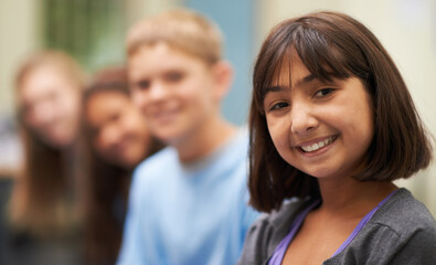 Girl, portrait and happy in corridor at school with confidence and pride for learning, education or knowledge. Student, person or face with smile in building or hallway before class or ready to study