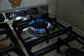 kitchen gas stove alight with flame coming out of it. Conceptual photo for gas, cost of bills, rising prices, heat and the environment. metal Ukraine, Russia, Europe. blu flame. united states. cook