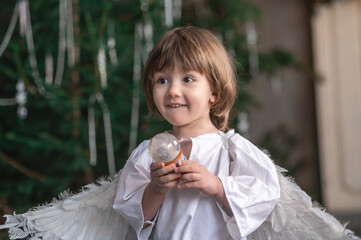 boy in white with wings in Christmas studio