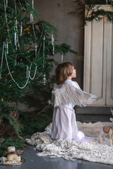 boy in white with wings in Christmas studio