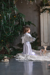 boy in white with wings in Christmas studio