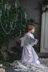 boy in white with wings in Christmas studio