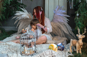 mother and son in white with wings in the Christmas studio