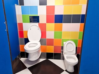 Shared family bright restroom with two toilet bowl in mall. Unisex WC for woman, man, mom dad, boy...
