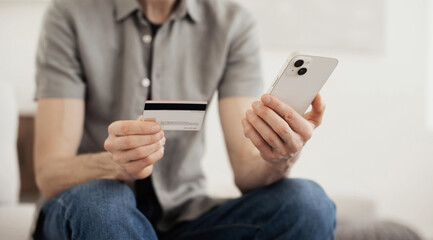 Man holding credit card and using smartphone at home, businessman shopping online , e-commerce,...