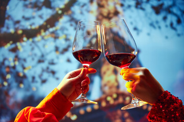 Two friends chased by glasses with wine near the the main attraction in France. Travelling and...