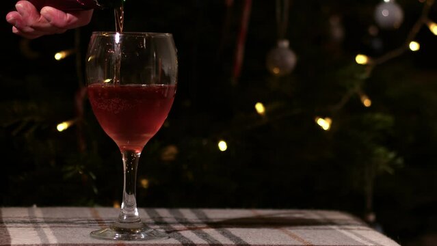 Pouring Glass of red wine on Christmas background