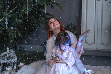 mother and son in white with wings in the Christmas studio
