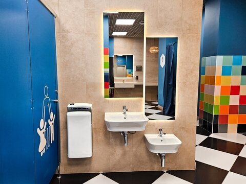 Shared family bright restroom in airport, mall. Unisex WC for mom, dad,little girl boy,child kid. Use together. Recreation room, toilet for adults, daughter,son. Separate cabins for parents,children