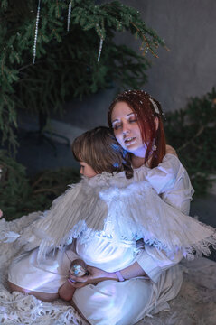 mother and son in white with wings in the Christmas studio