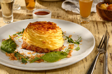 Meat topped with baked mashed potatoes, a Slavic-style potato casserole dish