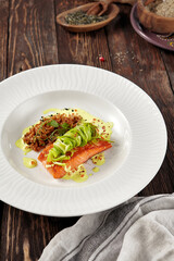 Grilled salmon steak with zucchini ribbons and wild rice on a white plate, rustic wooden backdrop