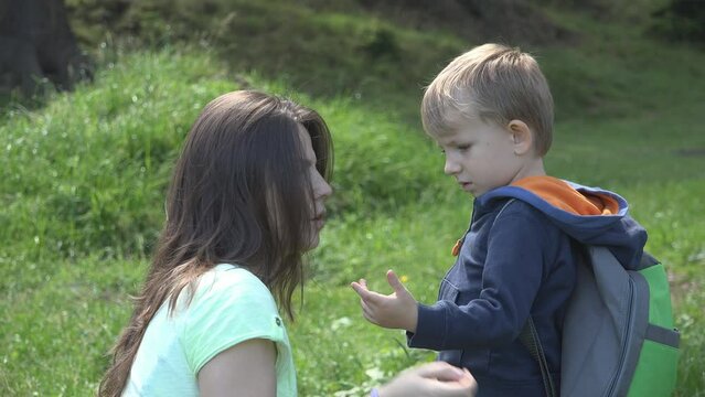 Mother comforts the child with an injured finger in nature