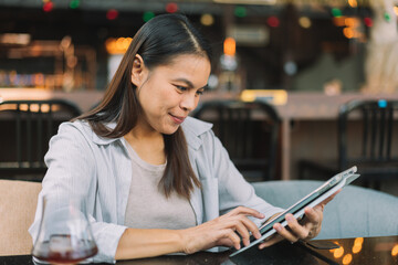 Portrait of beautiful asian woman with smartphone, relaxing in cafe, sitting and enjoying coffee while using tablet remote work business schedule planner.